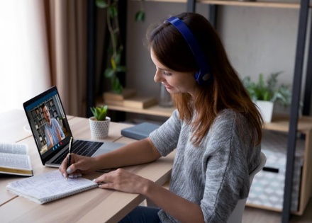 Woman conducting virtual meeting while working remotely