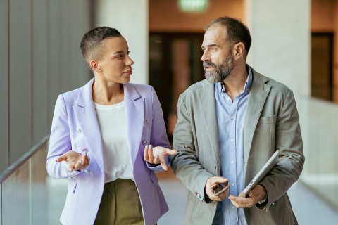 Business partners walking in an office building and discussing payroll taxes in Georgia