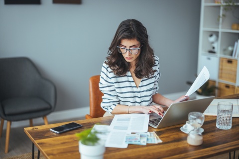 Businesswoman using a laptop to work on payroll taxes in the Czech Republic
