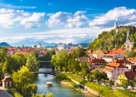 Panoramic view of Ljubljana Slovenia's river, forested hills, and old town