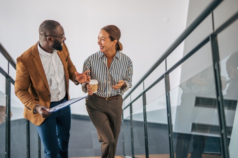 Colleagues in Brazil walking and talking downstairs in an office building