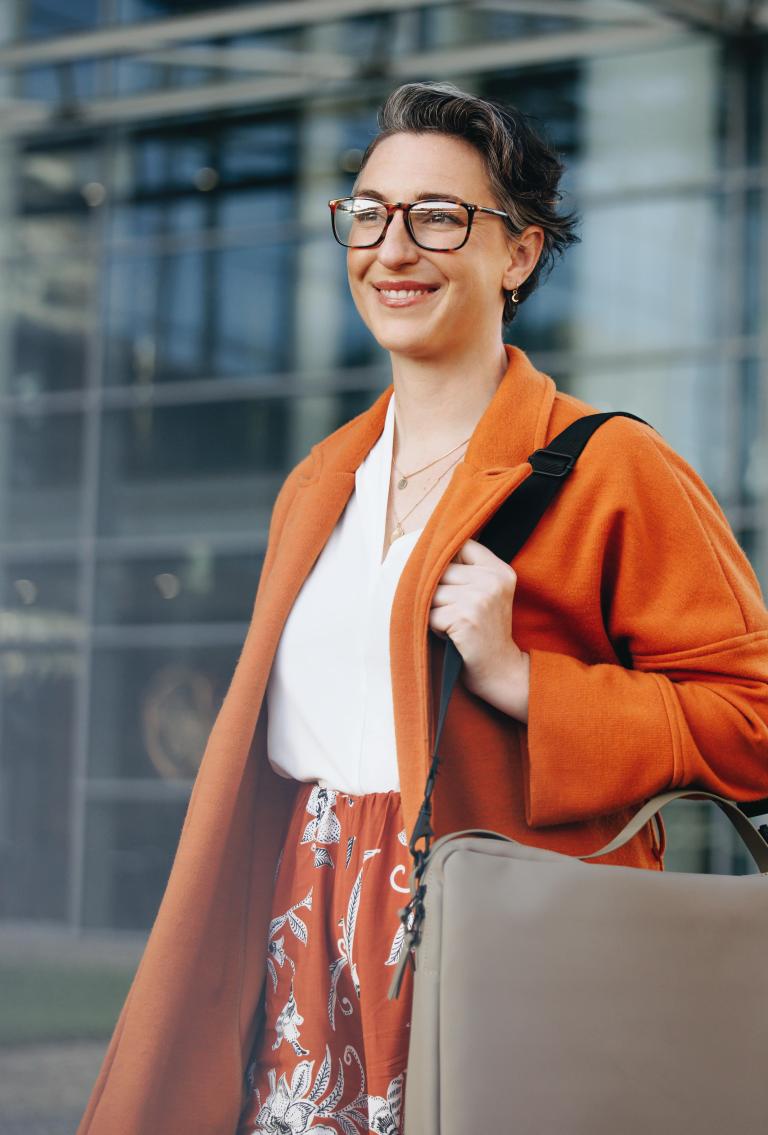 Woman in business attire confidently walking outside after partnering with Pebl.