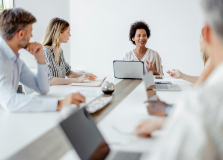 A team of contractors seamlessly and compliantly working together around a conference room table