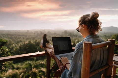 Digital nomad working on her laptop on a balcony