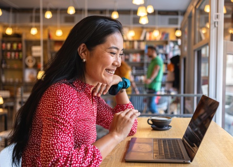 Woman smiling while looking at her laptop screen