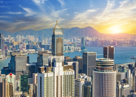 Aerial view of sunrise over Hong Kong's skyscrapers, bay, and mountains