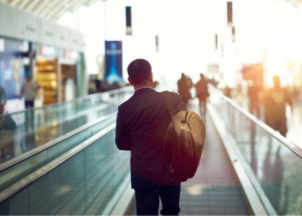 Businessman takes moving walkway to gate in airport