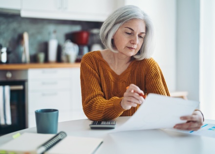 Mature woman sitting at table analyzing payroll taxes in Luxembourg