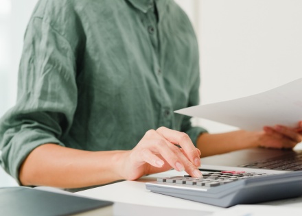 Business owner sitting at computer performing payroll audit
