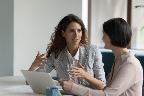 Two businesswomen discussing payroll taxes in Denmark