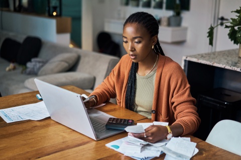 Young woman working from home and calculating payroll taxes in Ethiopia